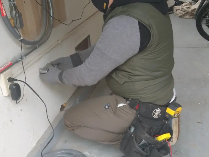 Electrician performing outlet wiring in a Mason garage